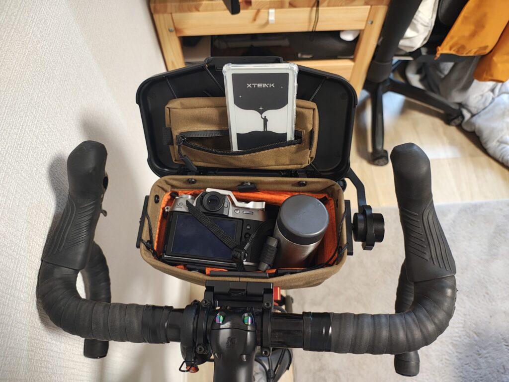 Routewerksのハンドルバーバッグの内容量を示す写真です。ミラーレス一眼カメラと小さなマグボトル、電子書籍リーダーを入れています。