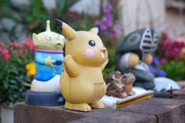 背景が大きくボケた、塀の上の古びたピカチュウの置物