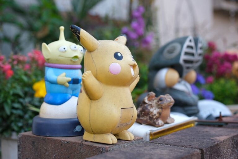 背景が大きくボケた、塀の上の古びたピカチュウの置物
